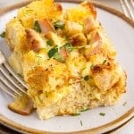 A slice of Eggs Benedict Casserole on a small dish with a fork.