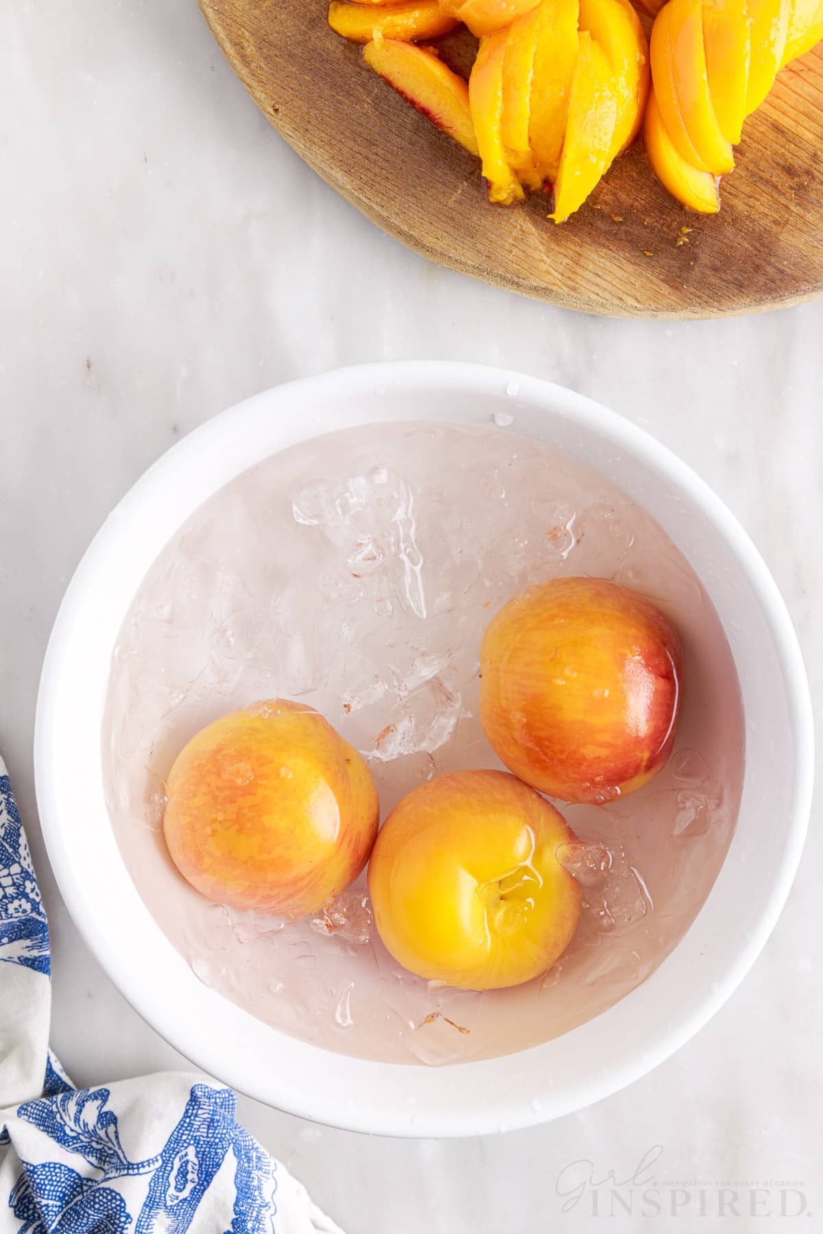 Three peaches in an ice water bath.