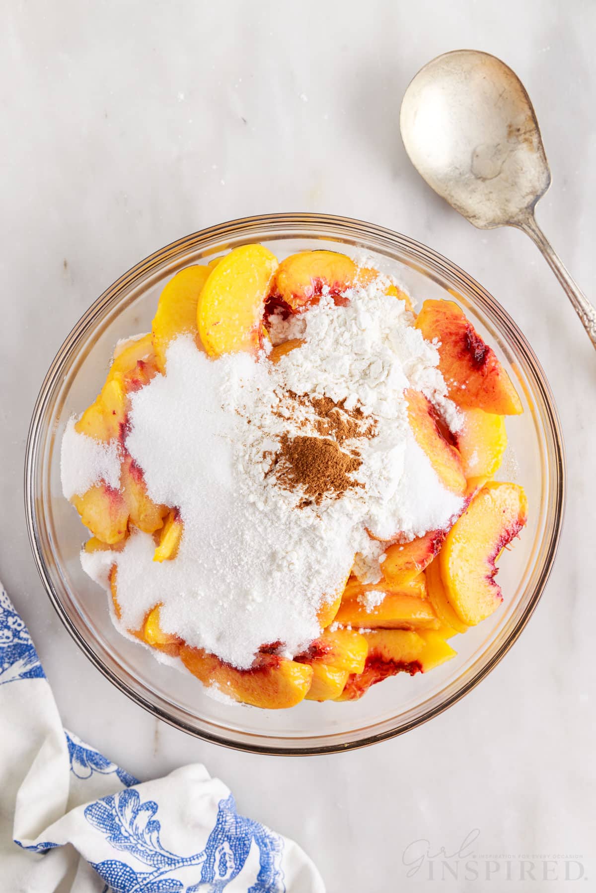 Flour and sugar added to sliced peaches.
