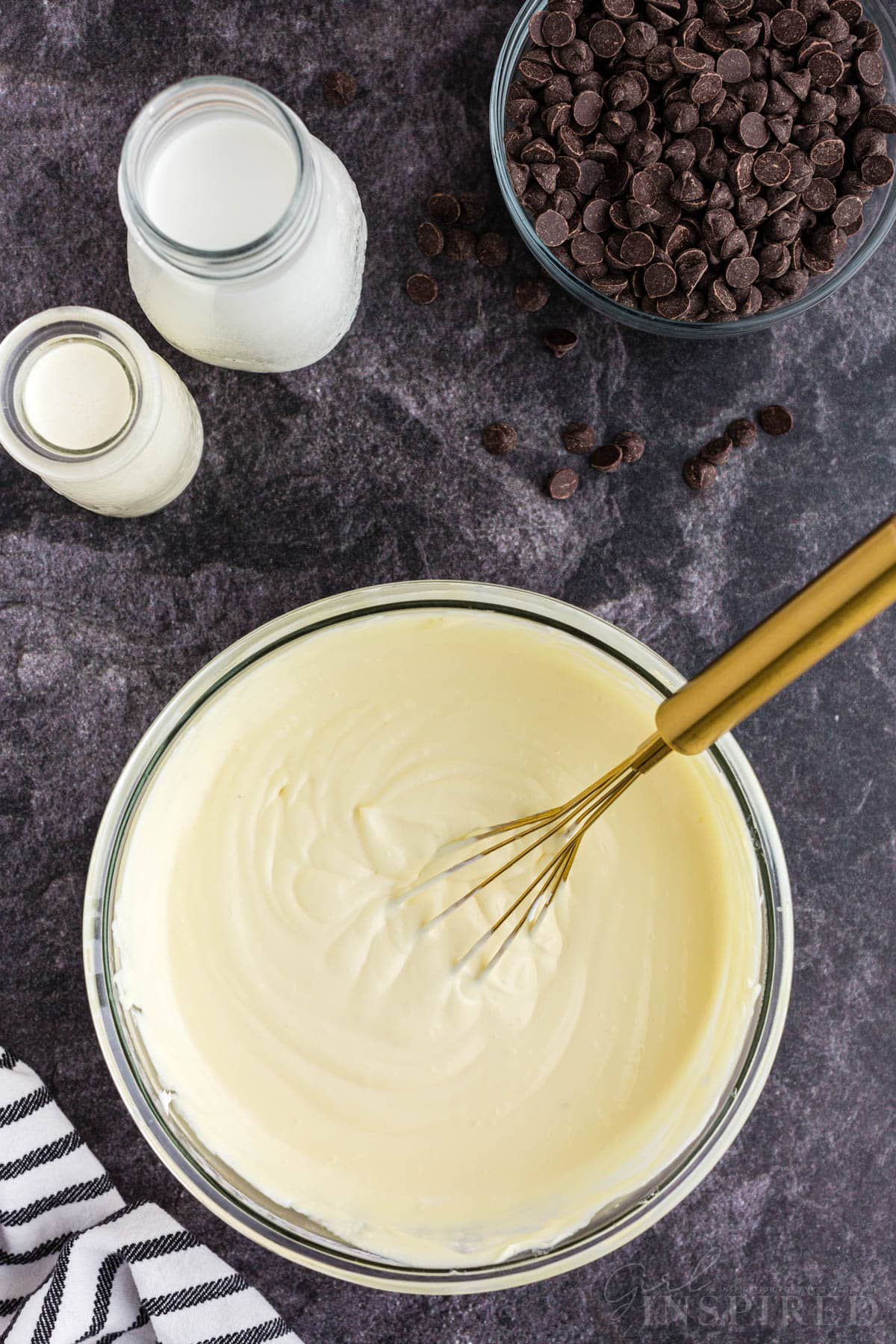 Mixing bowl with no bake eclair cake creamy filling, no bake eclair cake ingredients on the countertop.