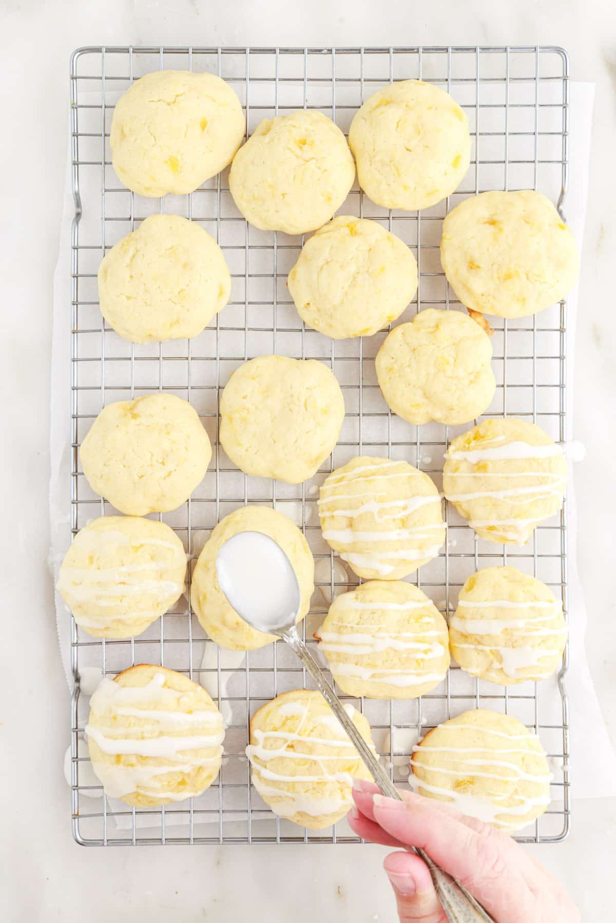 Glaze added to the top of the Pineapple Cookies on a cooling rack.