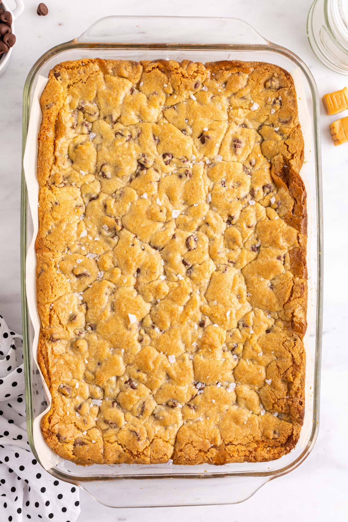 Overhead view of freshly baked salted caramel chocolate chip cookies in baking tray.