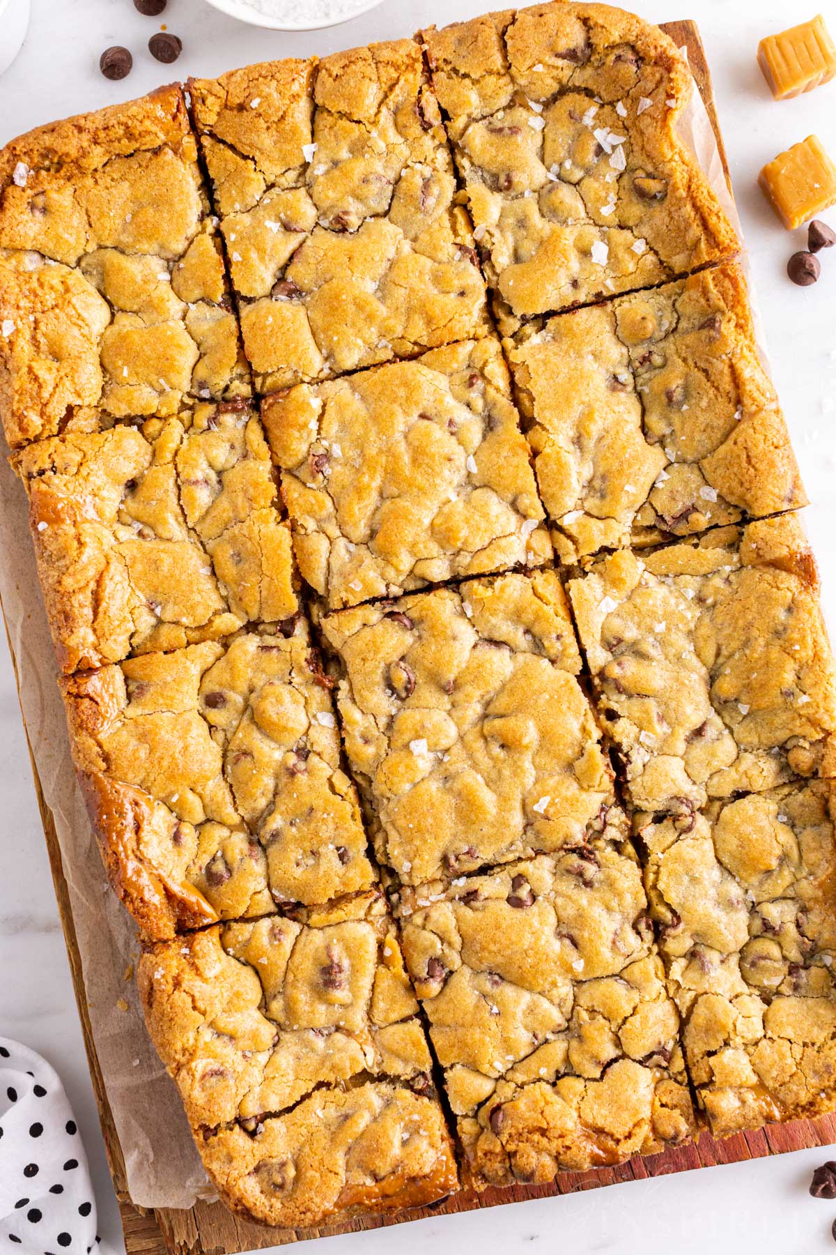 Overhead view of a tray of sliced salted caramel chocolate chip cookie bars. 