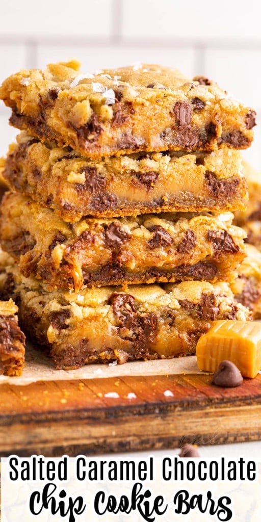 Stacked salted caramel chocolate chip cookie bars on a wooden kitchen board.