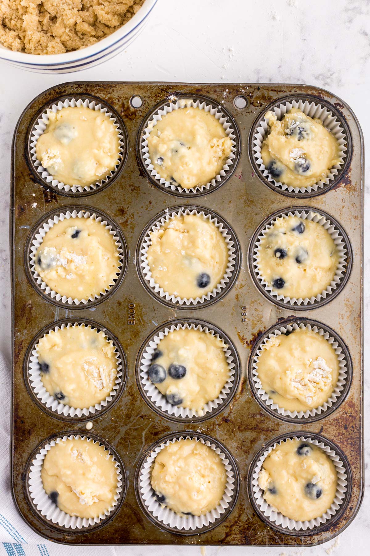 Sourdough Blueberry Muffins in a lined muffin tin before baking.