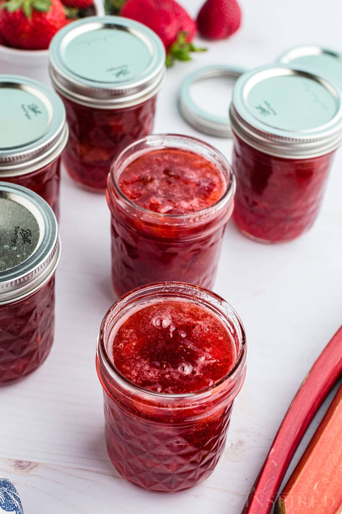 Several canning jars filled with strawberry rhubarb jam.