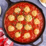 Overhead view of turkey meatballs in sauce in a large skillet.
