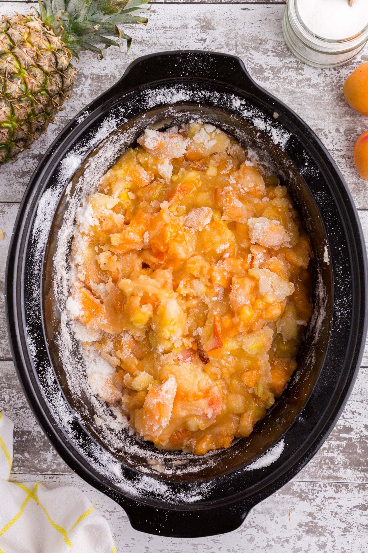 Crockpot with mixture of freshly chopped apricots, pineapple, sugar, and pectin.