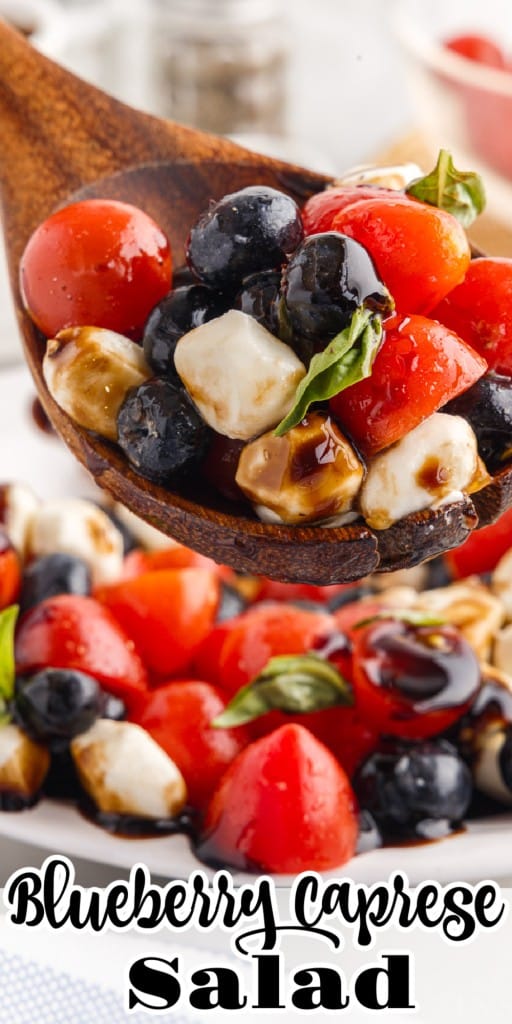 A serving spoonful of Blueberry Caprese Salad in front of a plate of it.