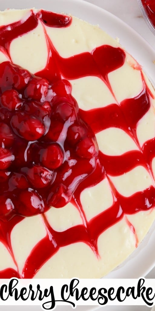 Overhead shot of cherry cheesecake on a white plate on white marble counter top