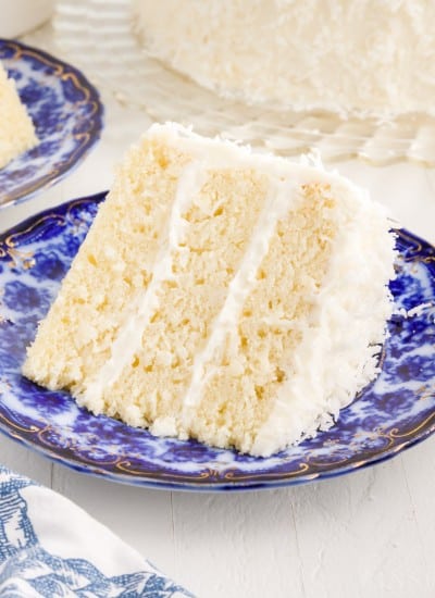 A decorative blue plate with a slice of Coconut Cream Cake on it.