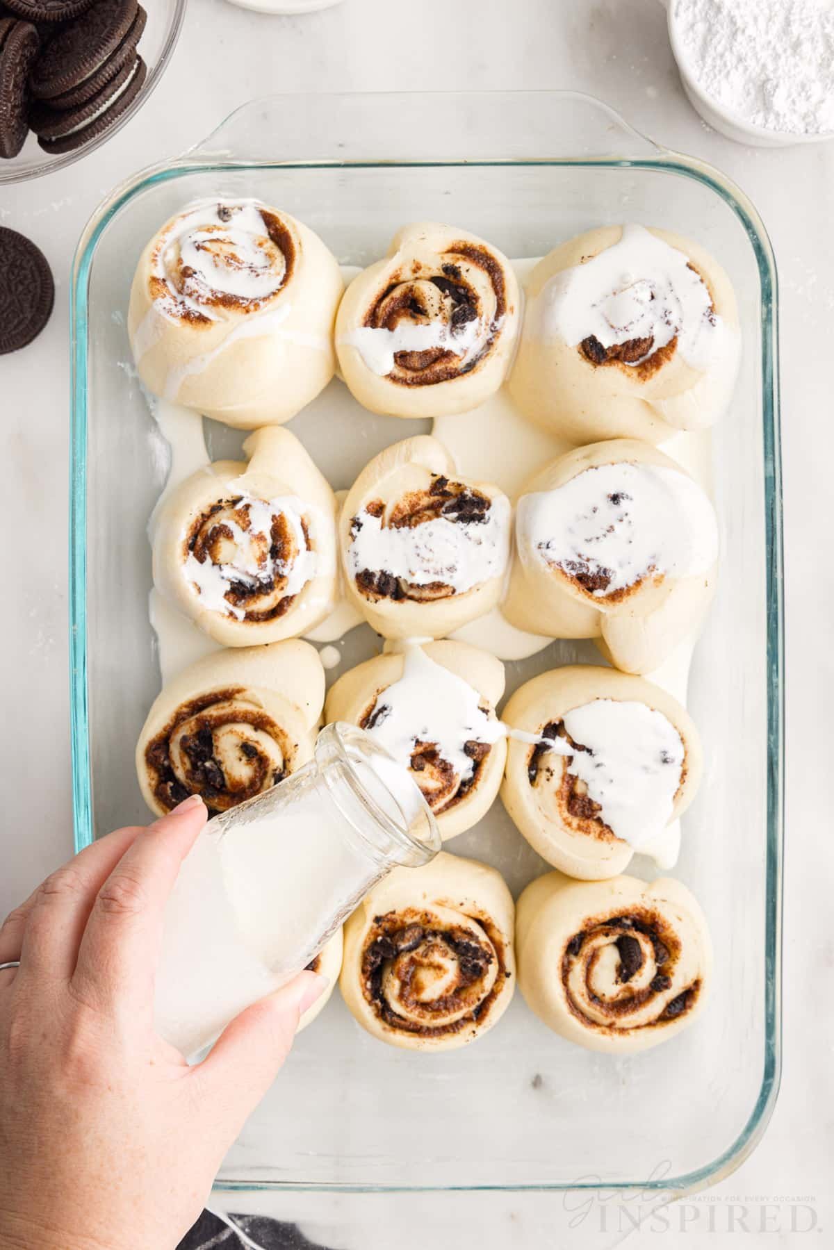 Heavy cream poured on top of cinnamon rolls.