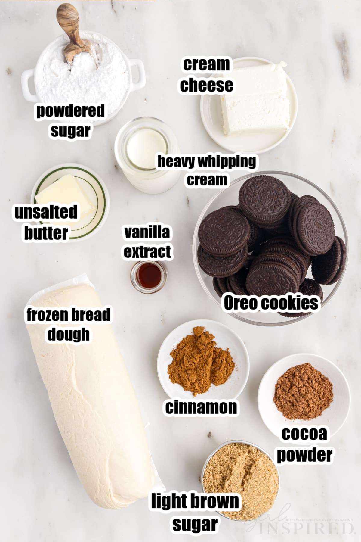 Bowls and plates containing individual ingredients for Cookies and Cream cinnamon rolls.