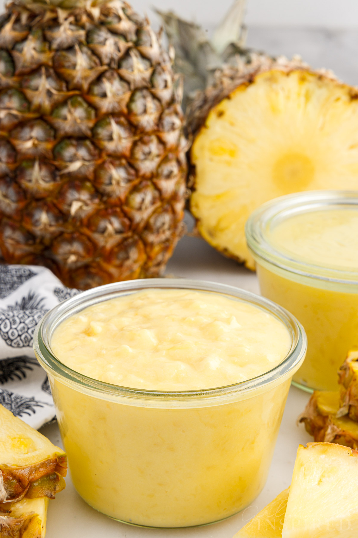 Mason jar filled with curd, a pineapple and additional jars.