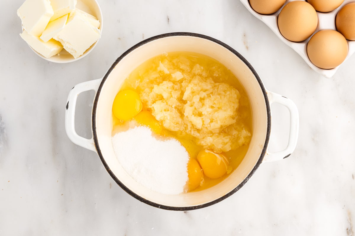Eggs, egg yolks, crushed pineapple, sugar, and lemon juice in a pot.
