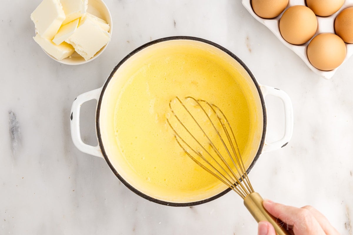 Ingredients for Pineapple Curd mixed together in a pan with a whisk.