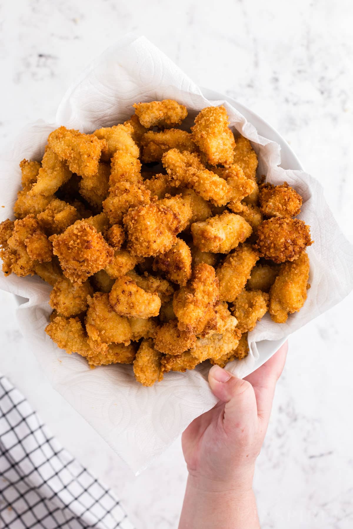 Popcorn chicken in a bowl with paper towel.