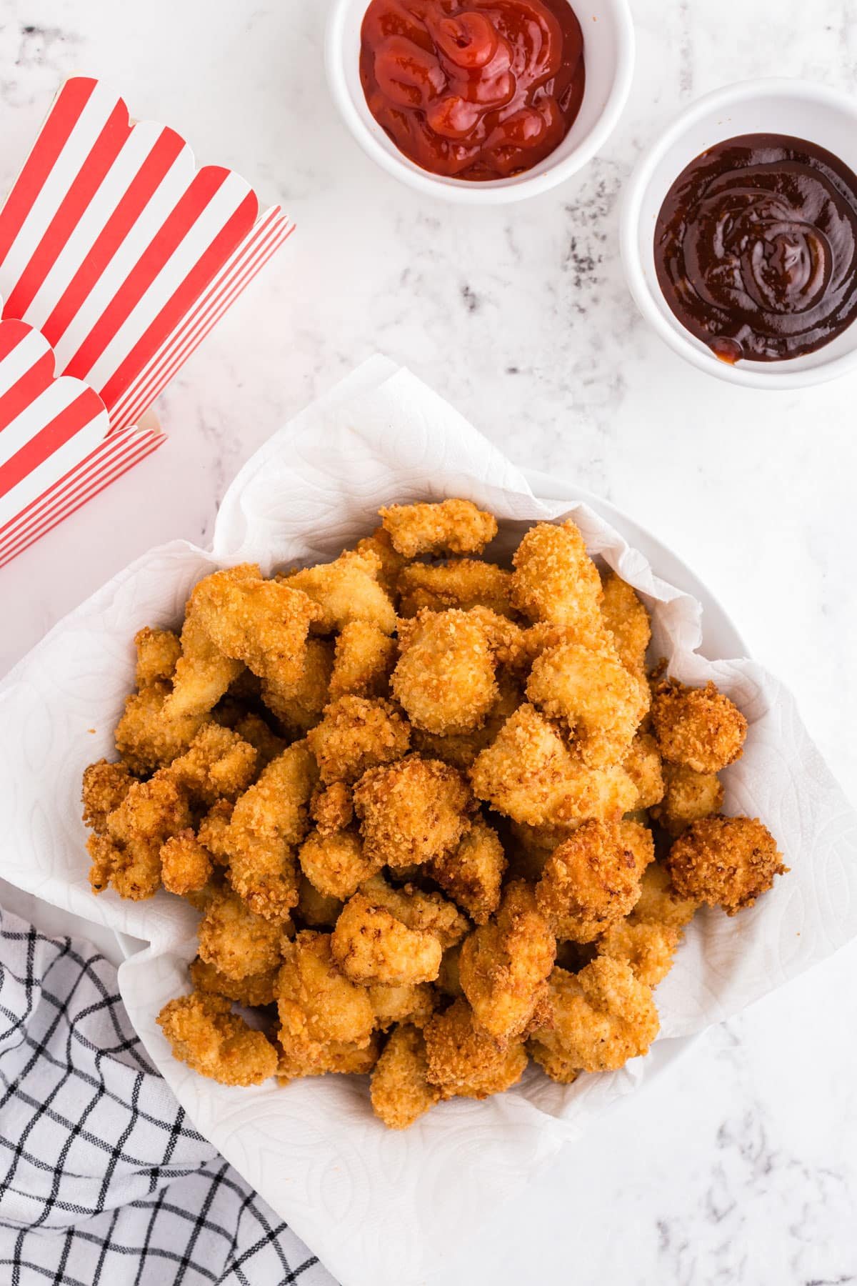 Overhead view of popcorn chicken with bowls of dipping sauce.
