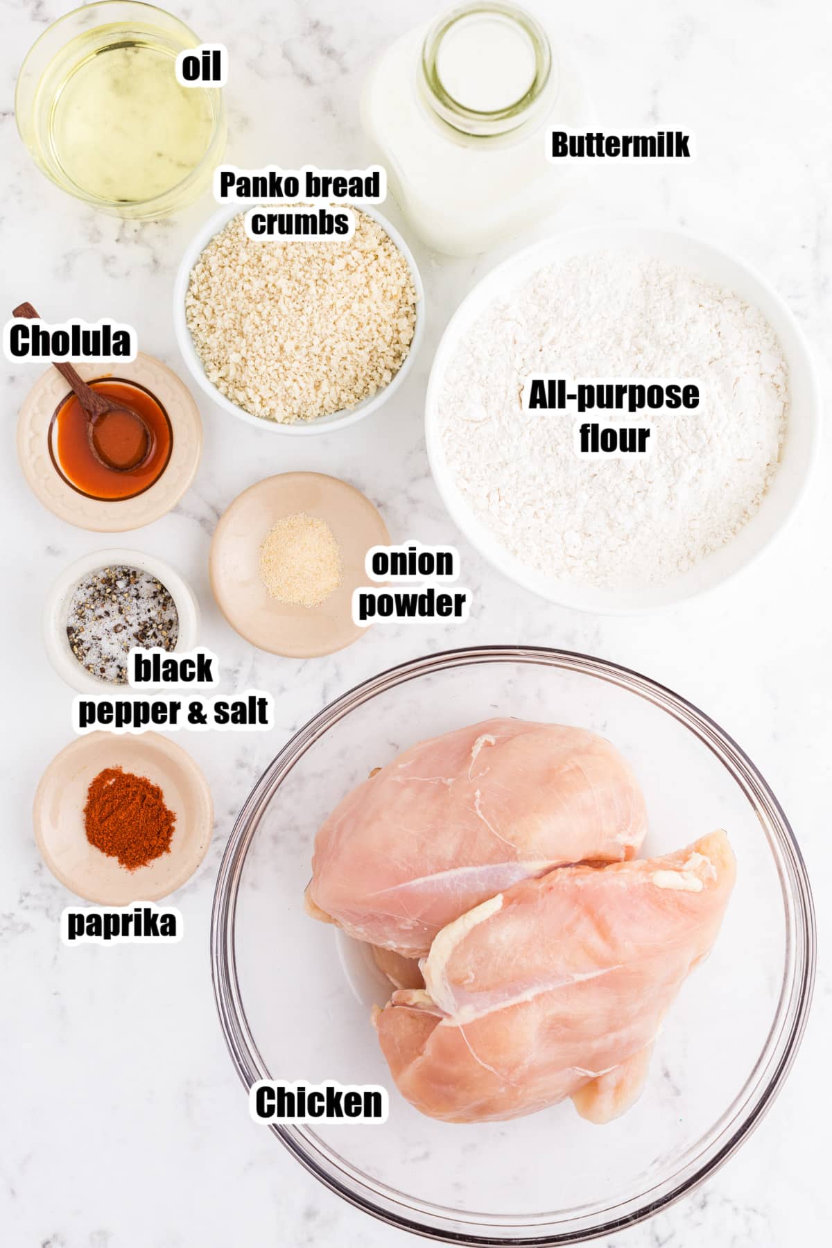 Popcorn chicken recipe ingredients on a white marble countertop.
