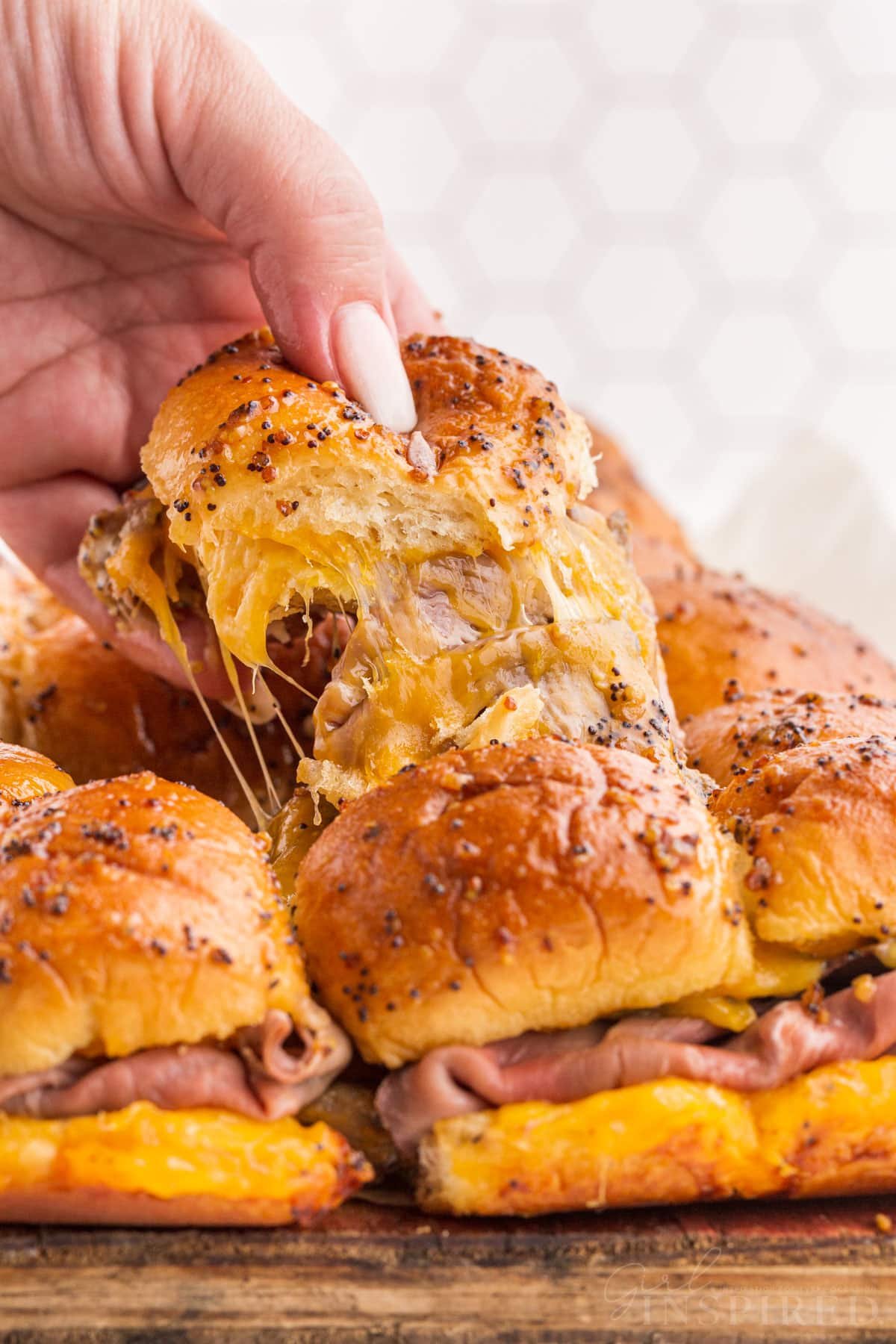 A Roast Beef Slider being pulled apart from the rest.