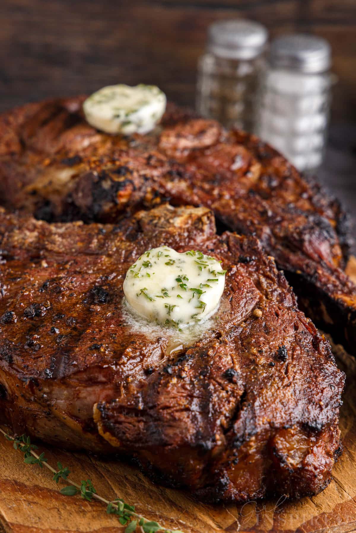 Close up of Tomahawk steak on a wooden kitchen board.