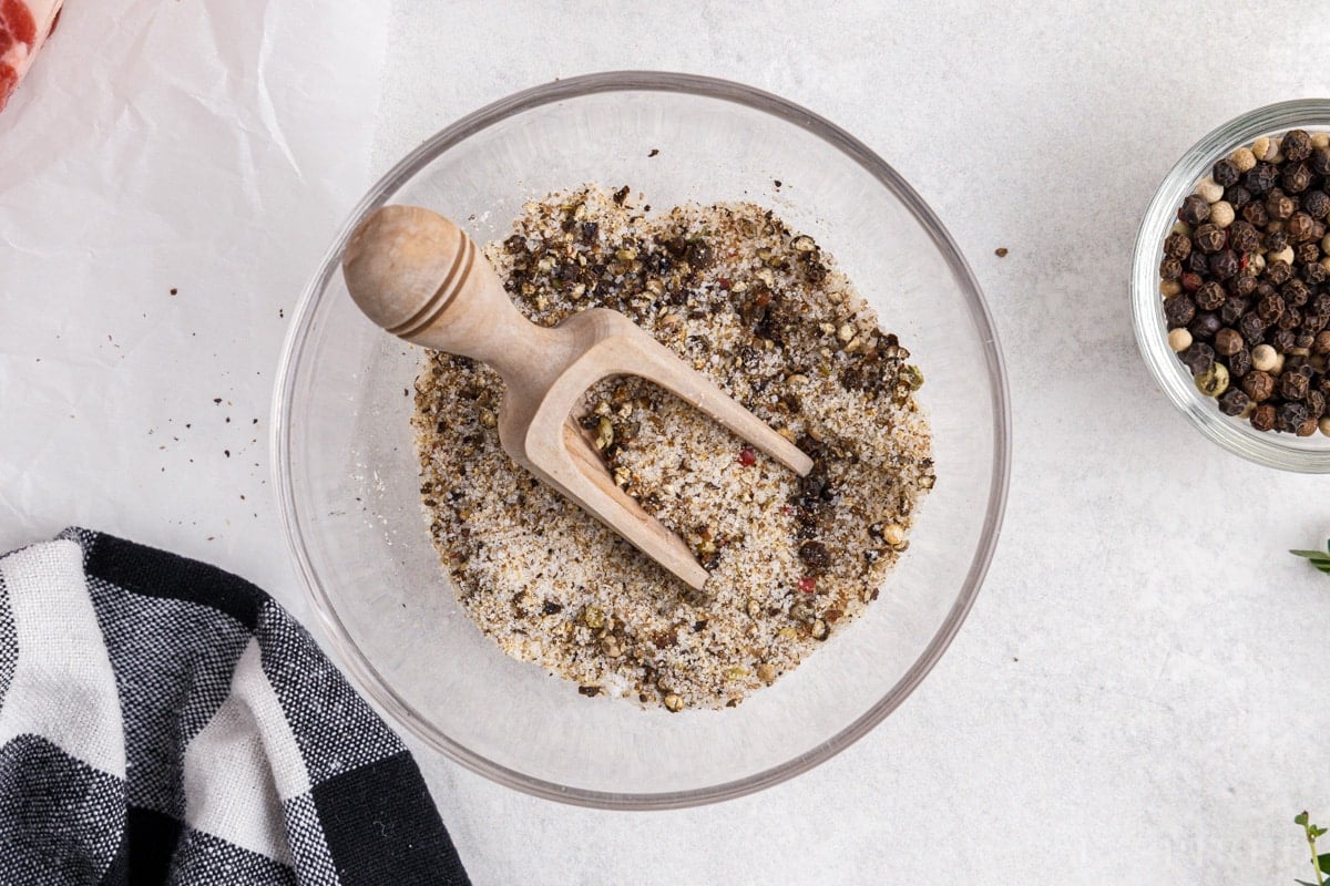 Small bowl with ground peppercorns, salt, onion powder, and garlic powder.