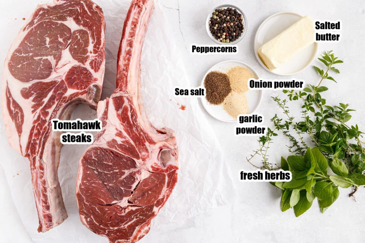 Tomahawk steak BBQ ingredients on a marble countertop.