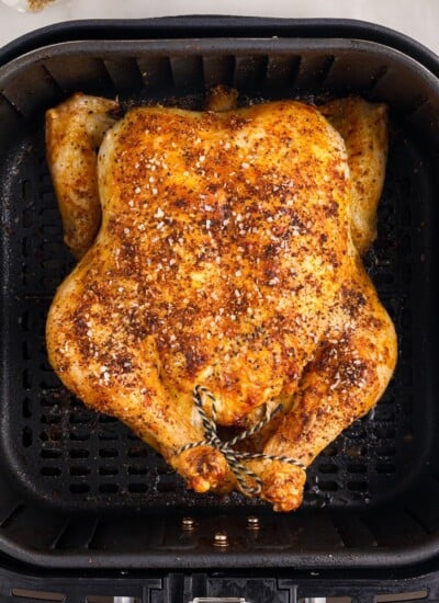 Close up overhead of whole chicken in air fryer.