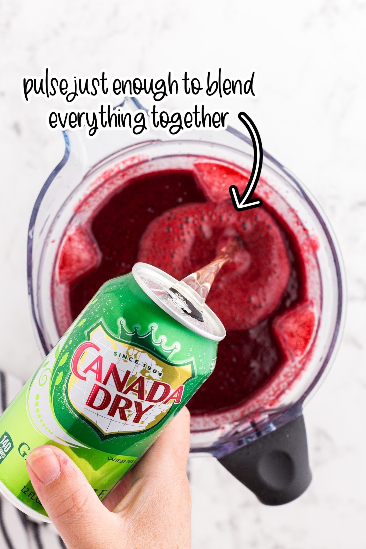 Ginger ale poured into blended berries with text overlay.