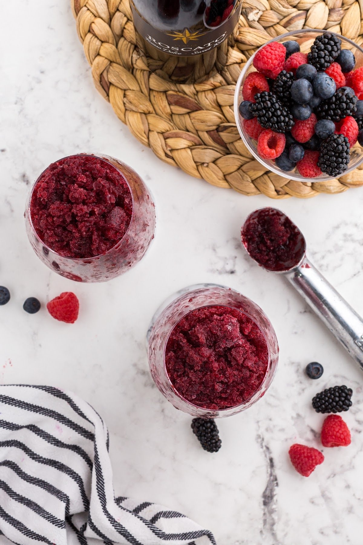 Overhead view of two Frozen Wine Slushies next to berries and wine.