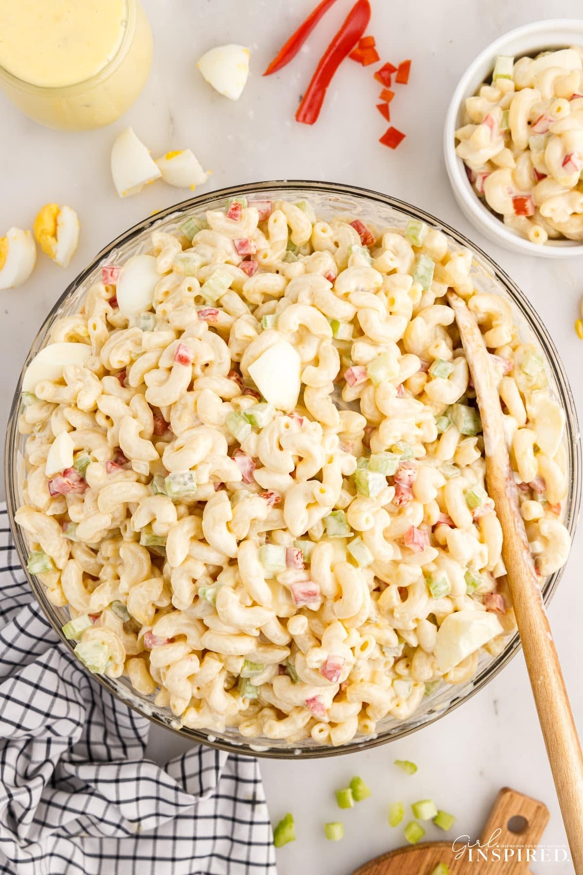 Overhead view of Amish Macaroni Salad with a wooden spoon inserted.