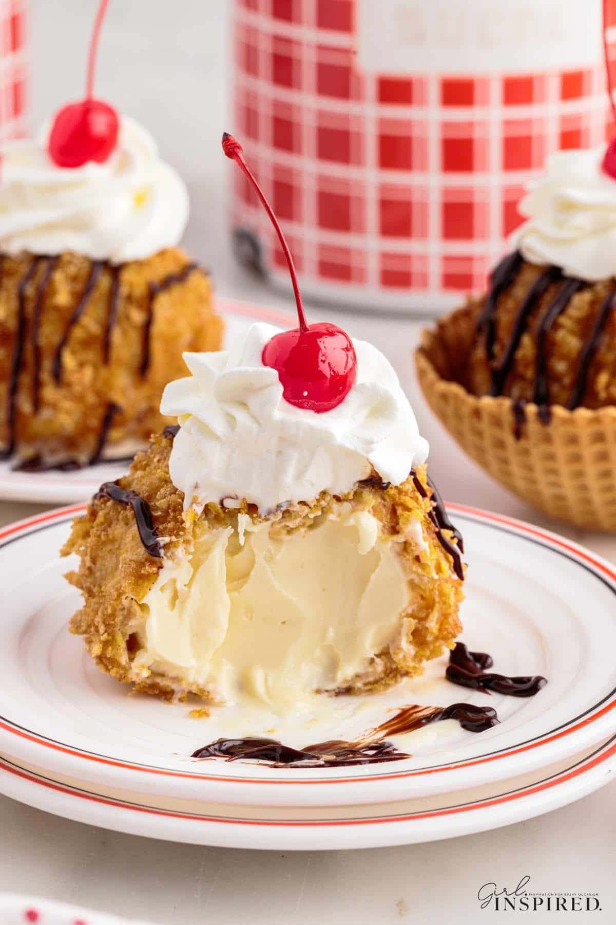 Deep fried ice cream with a bite taken out on a plate.