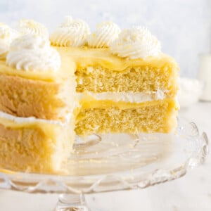 Lemon Sponge Cake with slices missing on a cake stand.