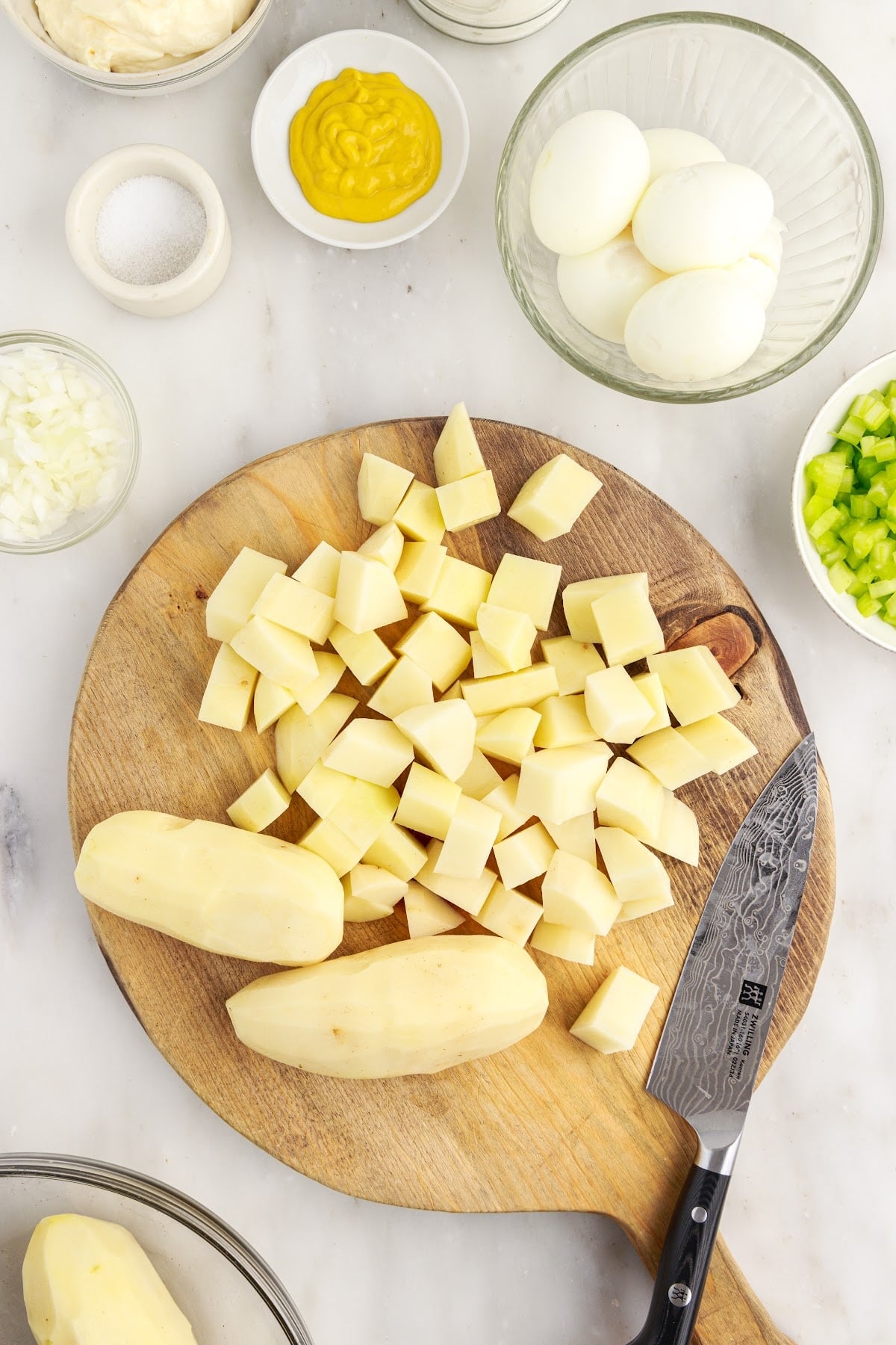 Potatoes chopped on a round cutting board.