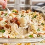 Close up of a spoonful of Chicken Bacon Ranch Casserole from a casserole dish.