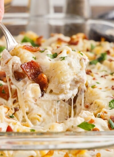 Close up of a spoonful of Chicken Bacon Ranch Casserole from a casserole dish.