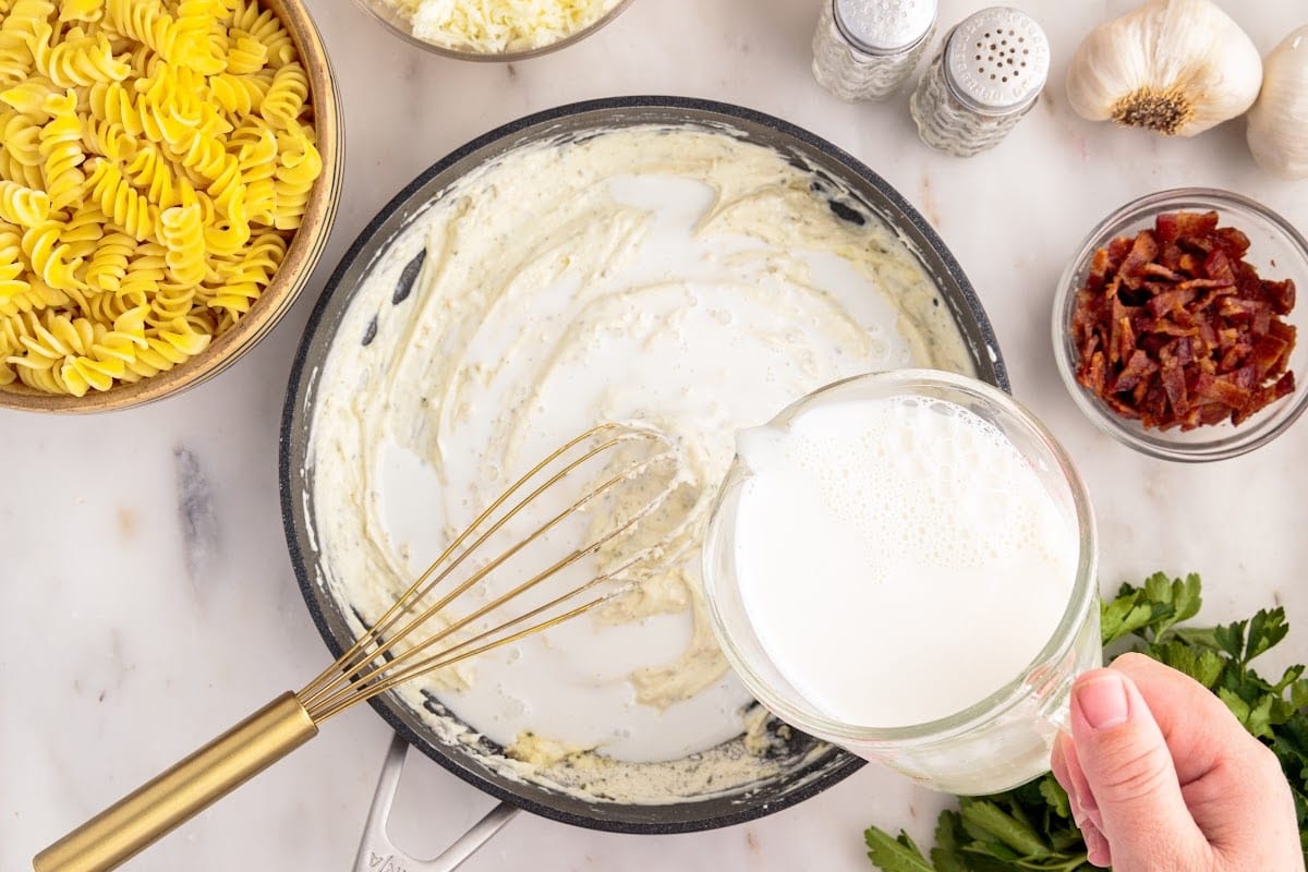 Milk added to cream cheese mixture in skillet.