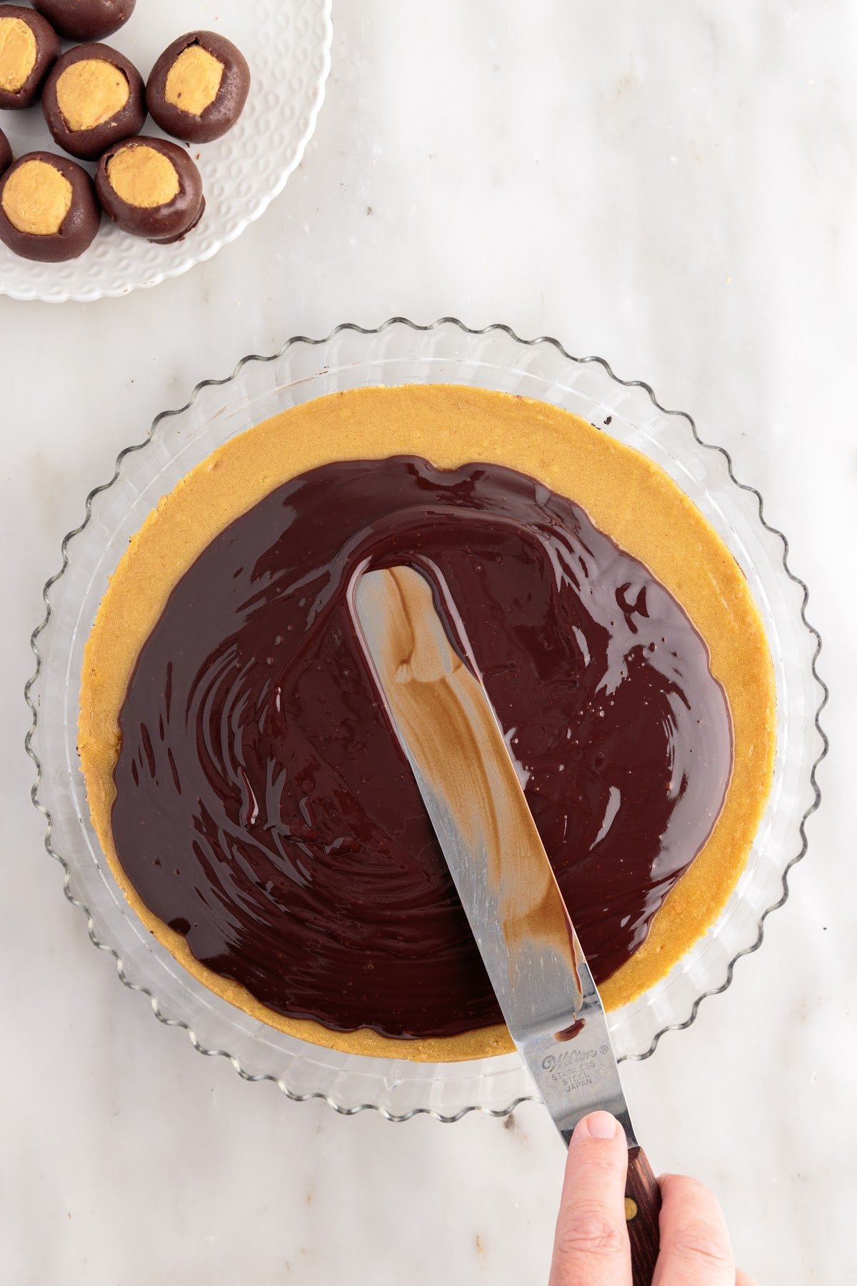 Ganache smoothed over the top of the Chocolate Peanut Butter Cheesecake.