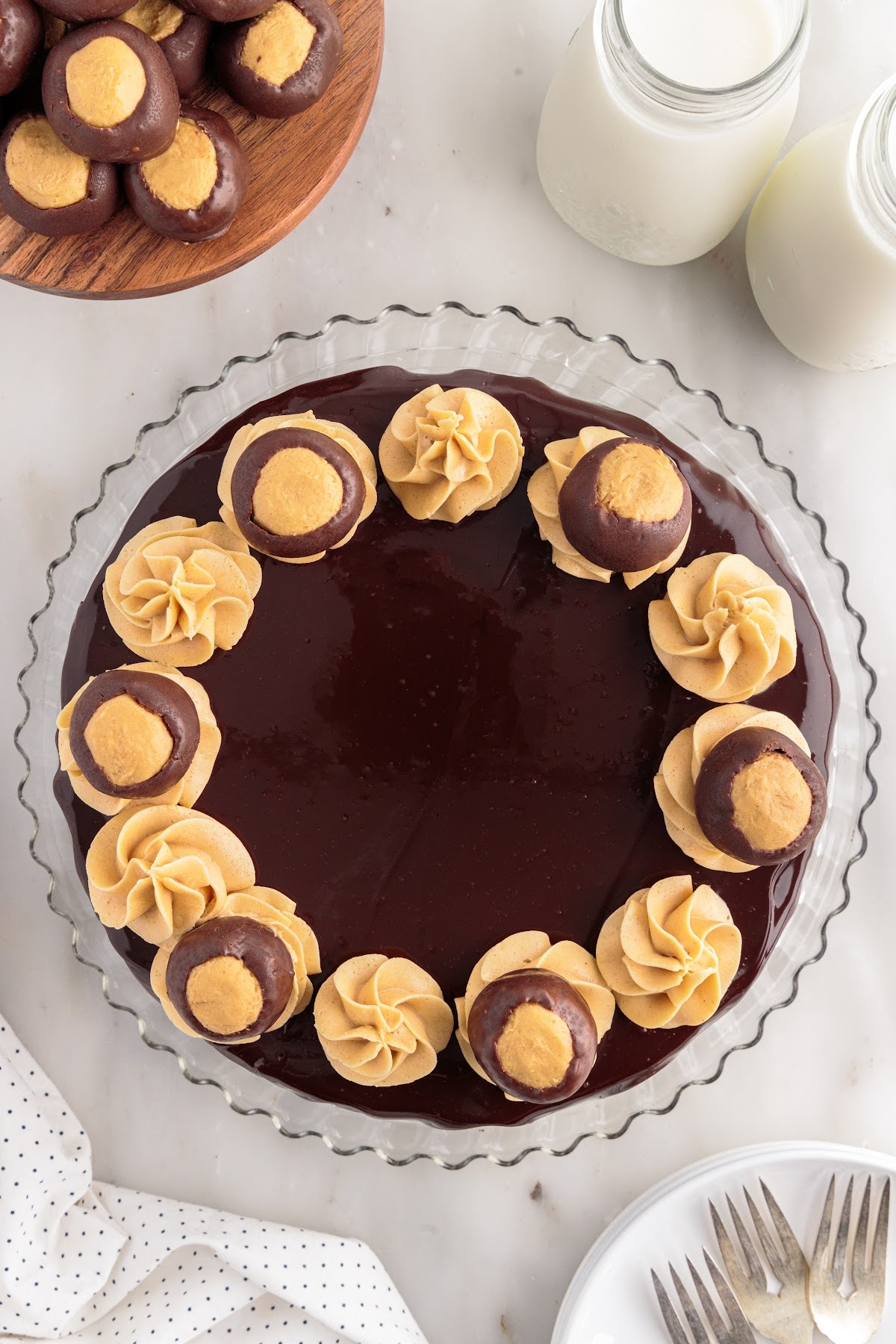 Buckeye cookies placed on every other swirl on the top of the Chocolate Peanut Butter Cheesecake.