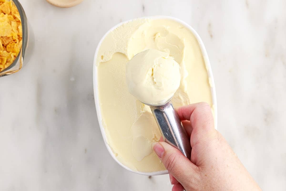 Scooping ice cream from the container.