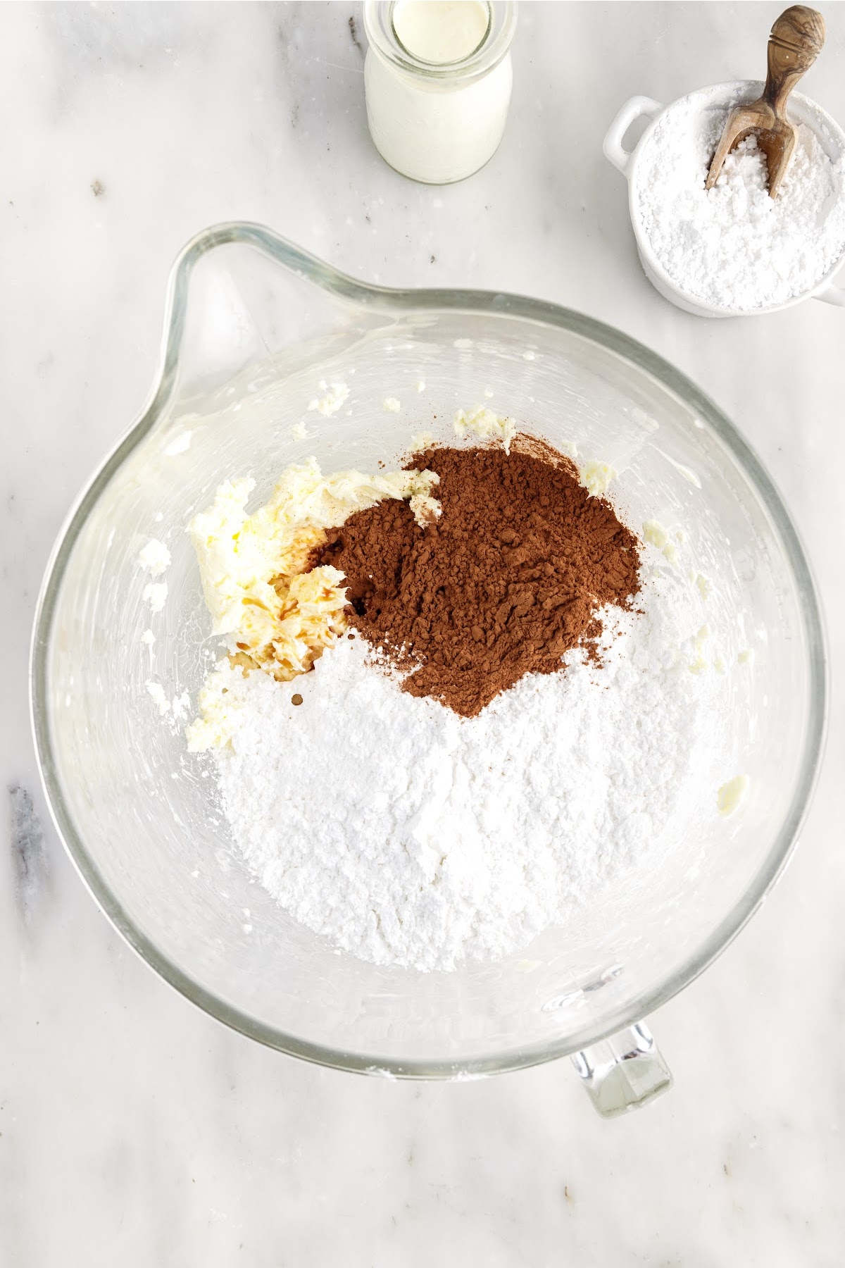 Powdered sugar, cocoa powder, and butter in a mixing bowl.