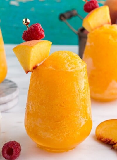Front close up of Peach White Wine Slushies with peaches and raspberries.