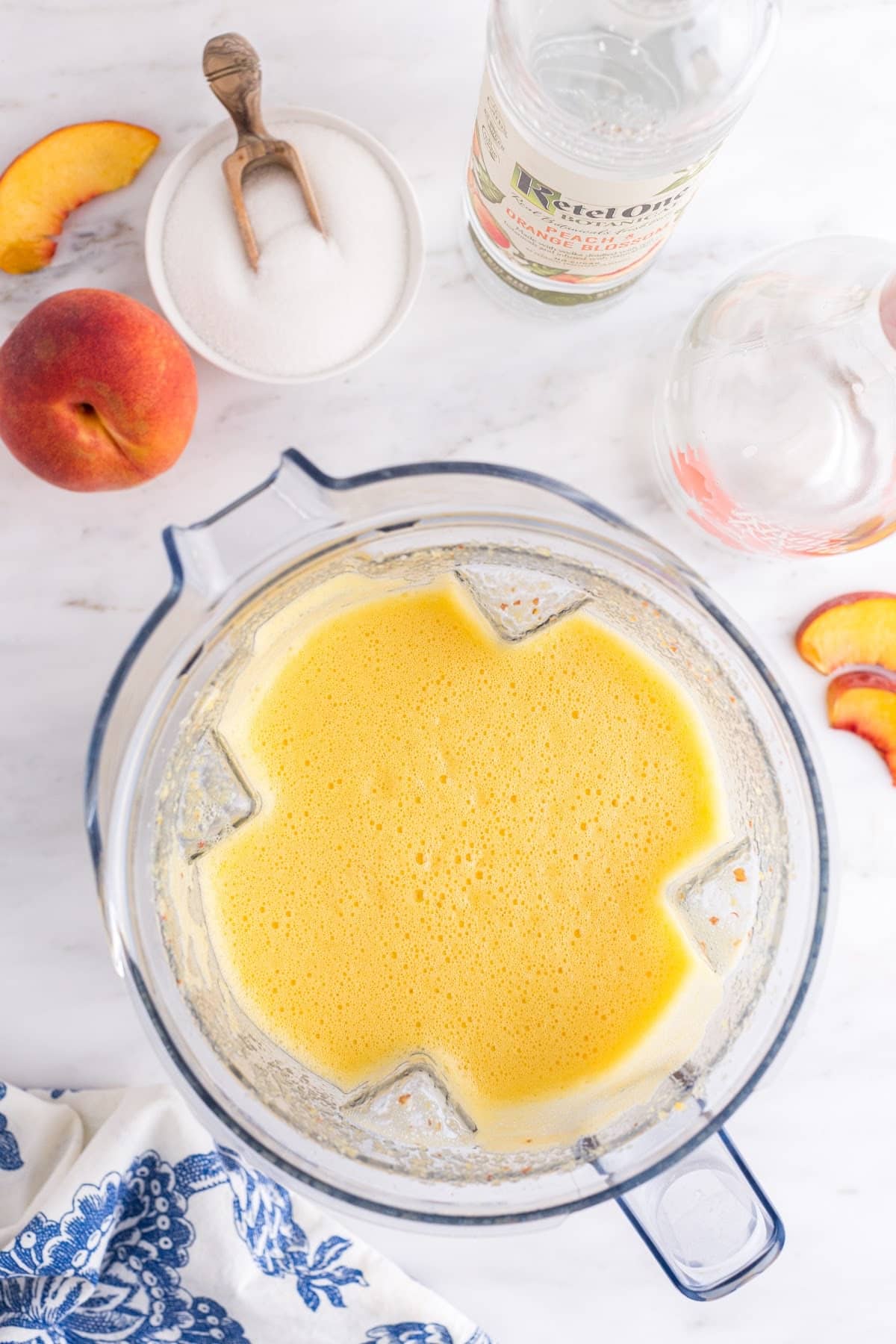 Overhead view of Peach White Wine Slushie ingredients in a blender.