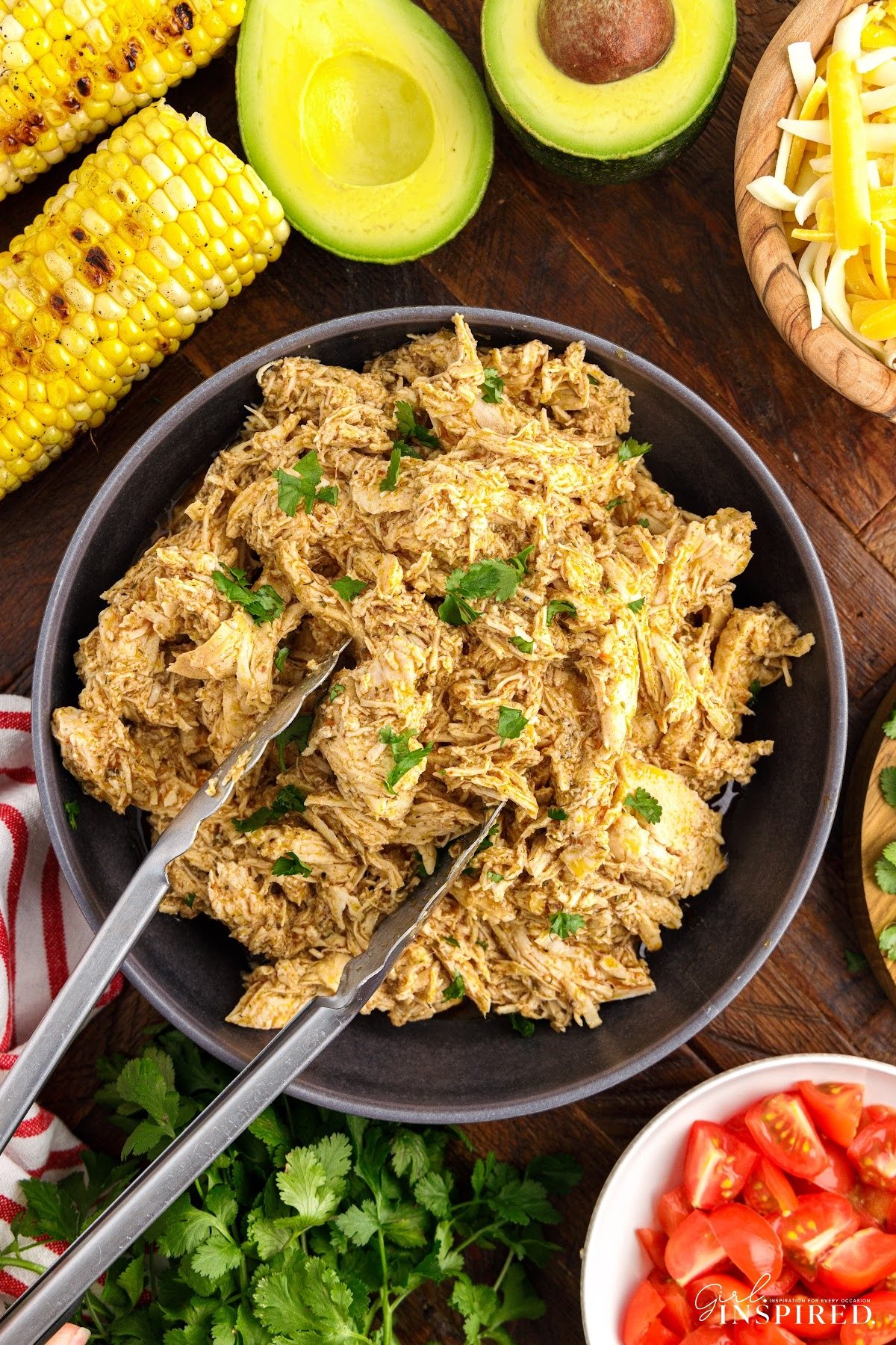 Shredded chicken with tongs.