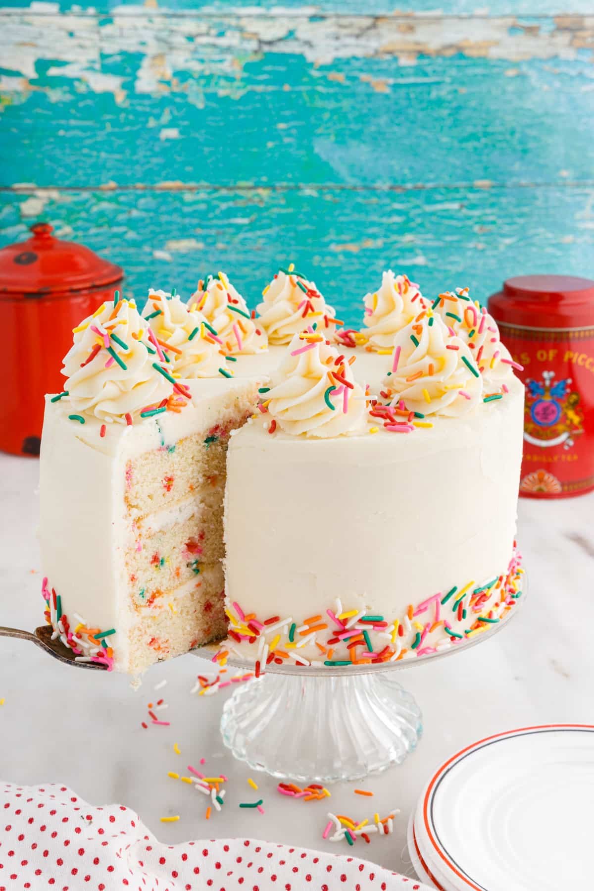 A slice being taken from a Funfetti Cake.