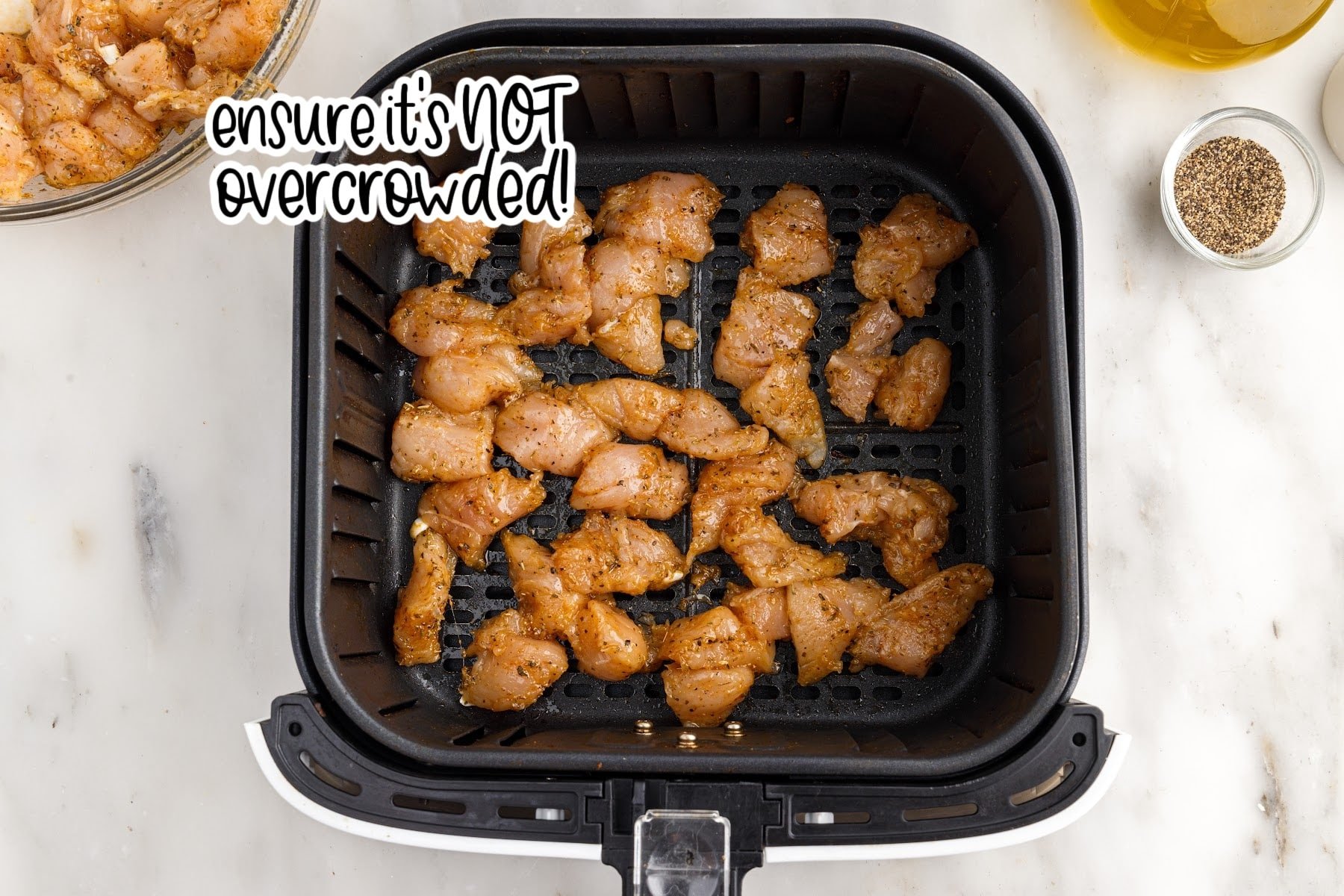 Chicken pieces added to the air fryer with text overlay.