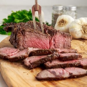 Front view of an Air Fryer Roast Beef on a cutting board slices cut from it.