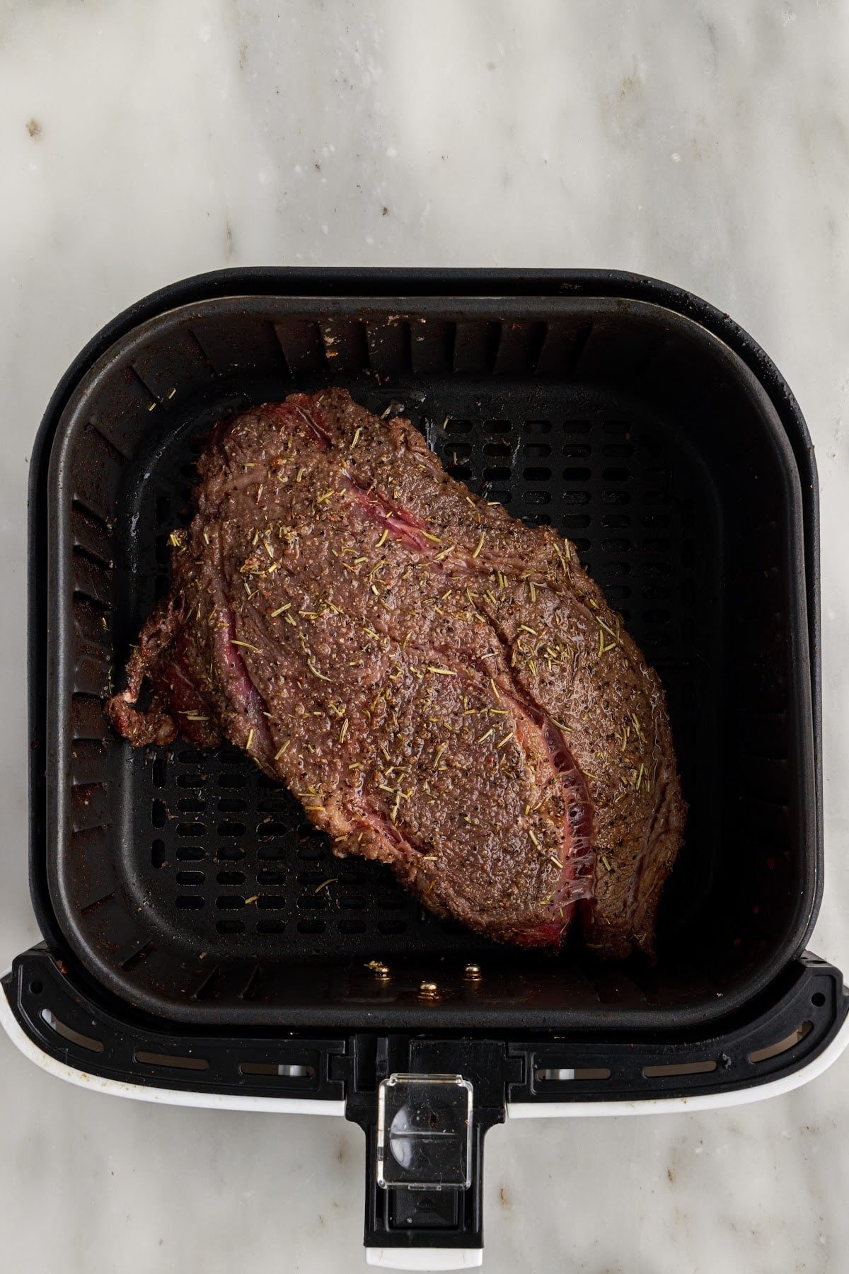 Air Fryer Roast Beef in an air fryer after being cooked.