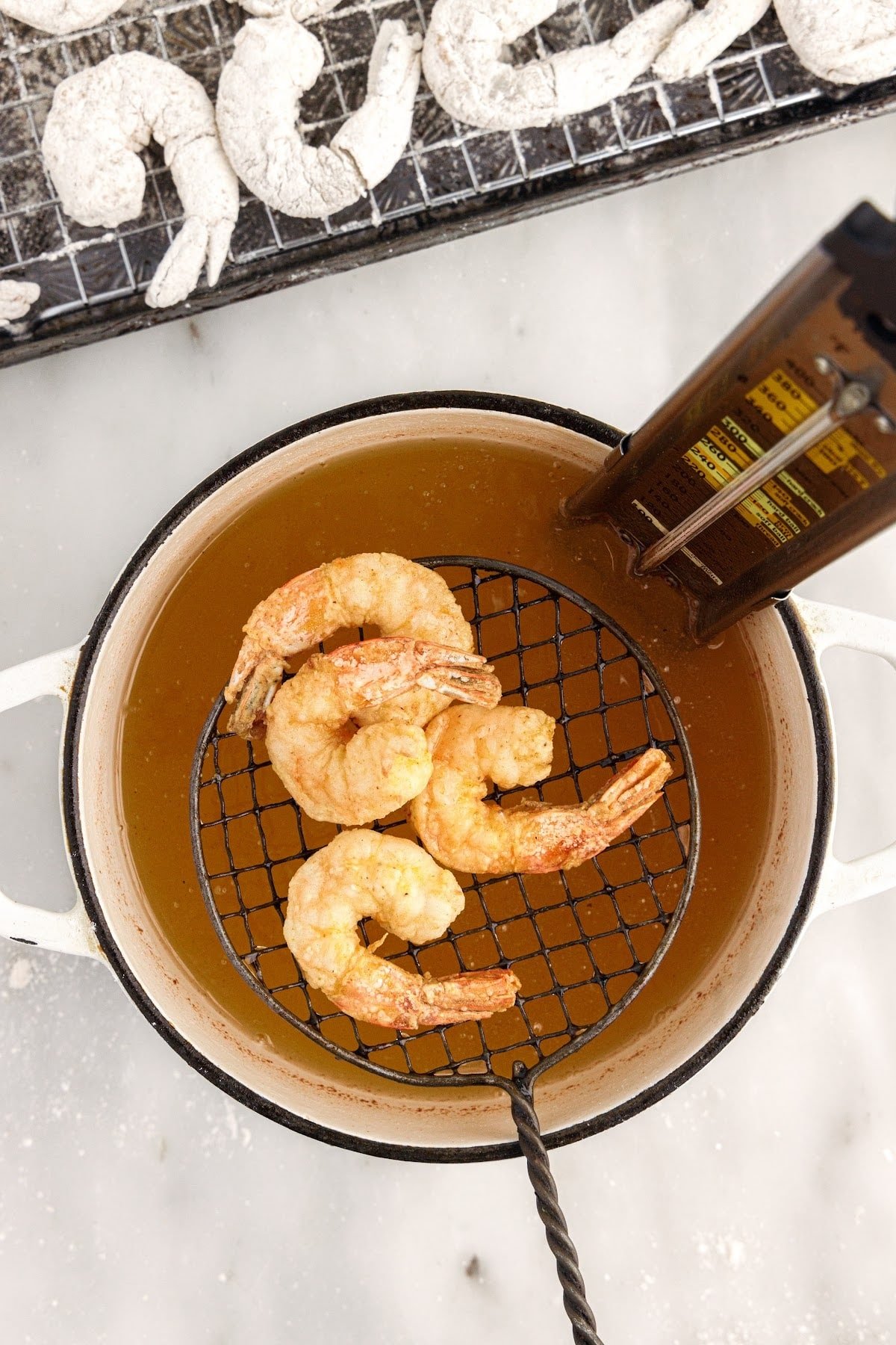 Buffalo Shrimp after being placed in hot oil on a strainer.