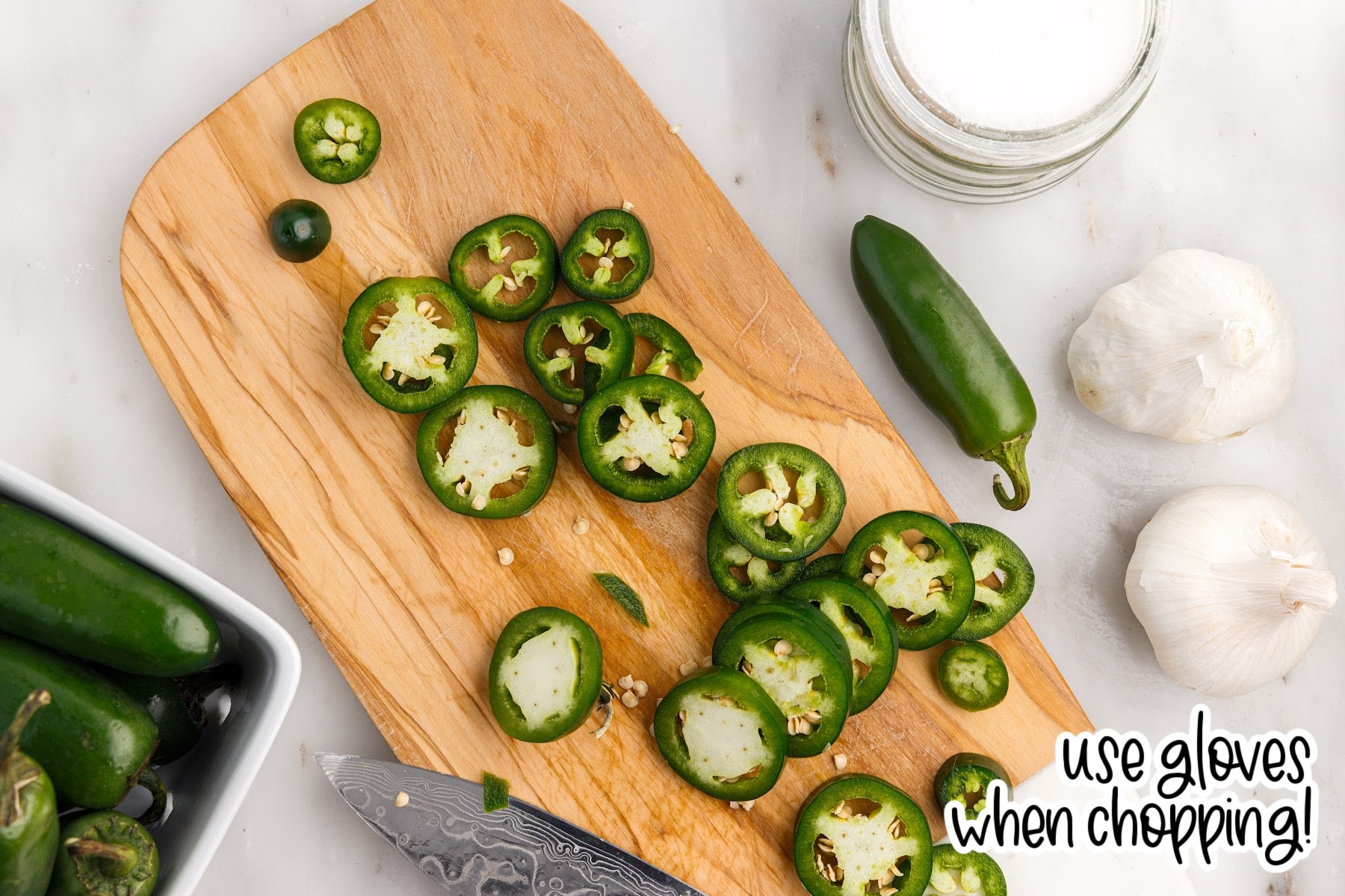 Jalapenos on a cutting board with text overlay.